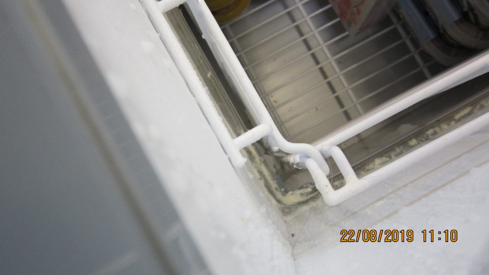  Na predajnej ploche v oddelení mrazených potravín v mraziacom boxe je znečistené dno tohto zariadenia nečistotami, plastom a na boku zaschnutou tekutinou a námrazou.