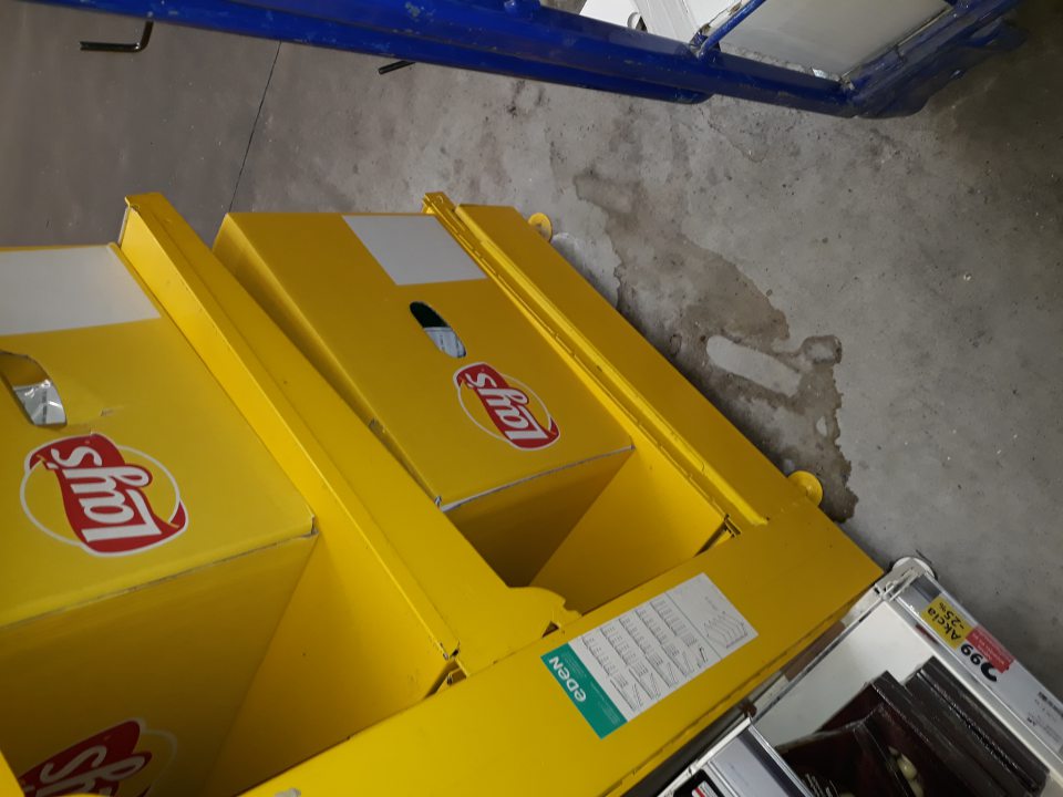 Znečistená podlaha pod regálom s čipsami Lays