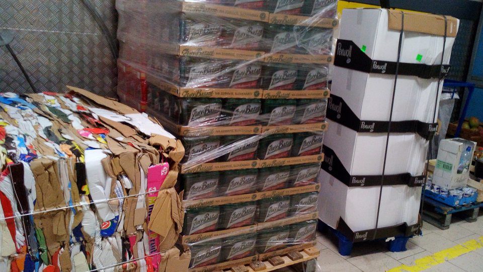 Skladovanie prázdnych kartónových obalov v sklade za lisom na kartóny, v tesnej blízkosti sú umiestnené palety s balenými potravina
