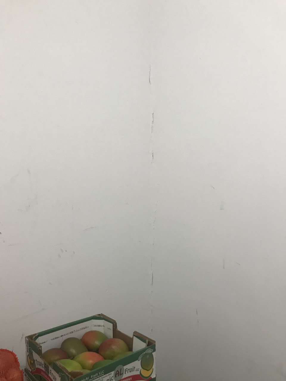 Poškodená omietka steny v sklade ovocia a zeleniny