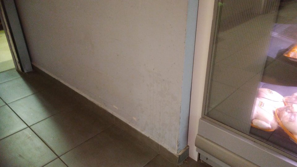 Znečistený povrch steny na prechode z predajne do skladu