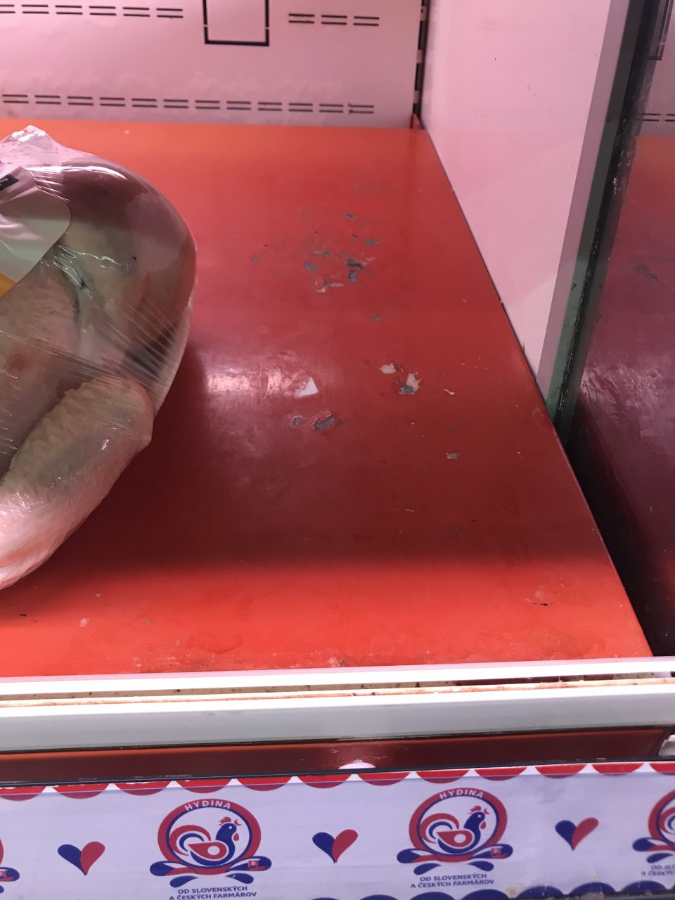 Poškodený náter regálov na chladiacej vitríne s čerstvou hydinou na predajni 