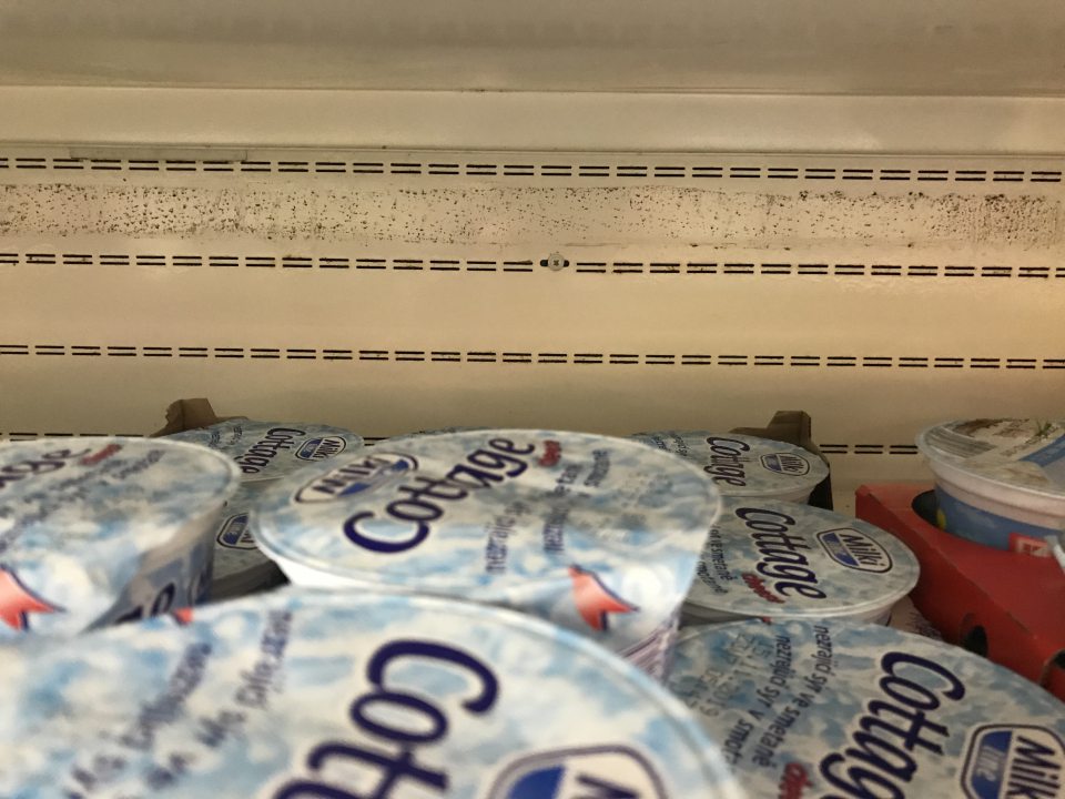 Znečistené zadné steny na chladiacich vitrínach s mliečnymi výrobkami na predajni