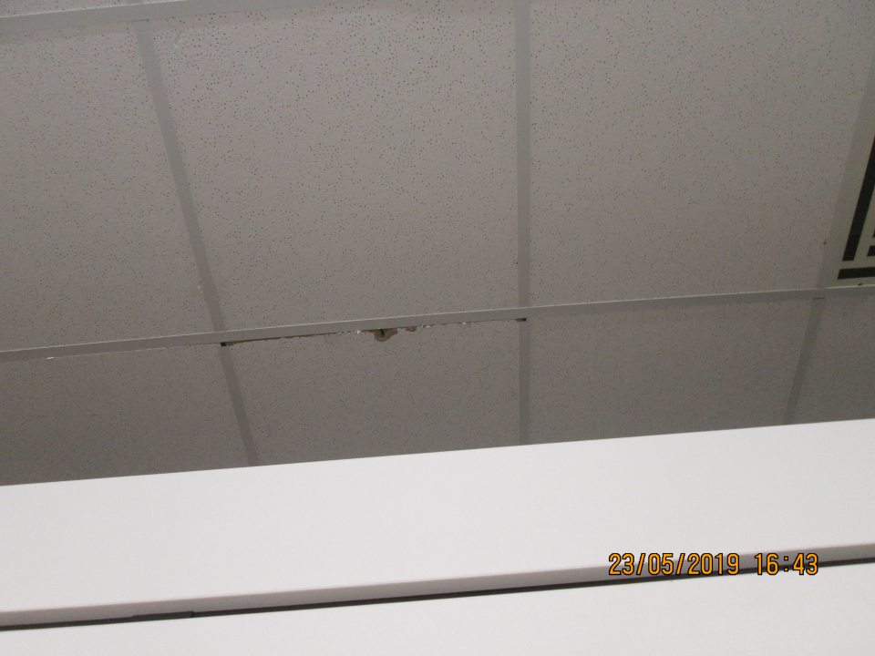 Poškodená stropná kocka v priestoroch nad chladiacim zariadením s uloženými mliečnymi výrobkami na predajnej ploche v rozsahu cca 30 cm x 2 cm.