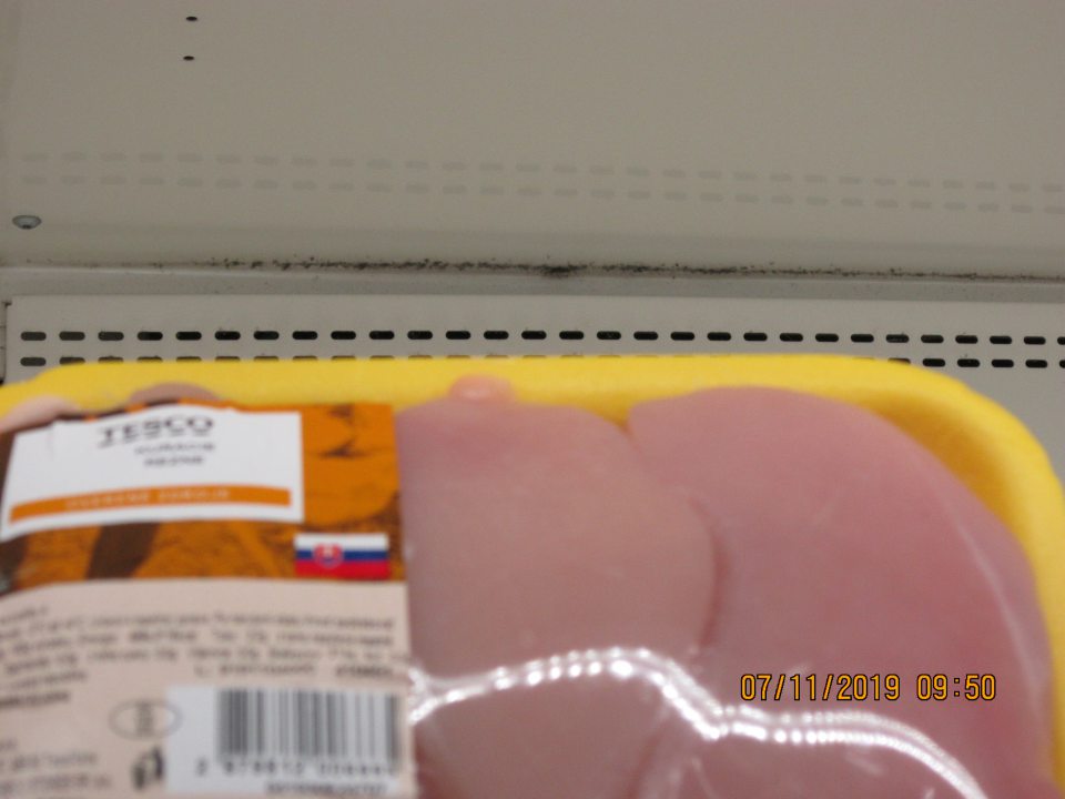 V chladiacej vitríne na chladené balené hydinové mäso v hornej časti regálov výskyt čiernej plesne a prachu.