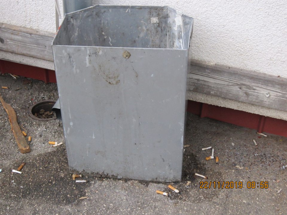 Z vonkajšej strany príjmovej rampy pri vstupných dverách sa nachádzajú odpadky (zvyšky obalov, drevené prepravky, odpad z cigariet). 