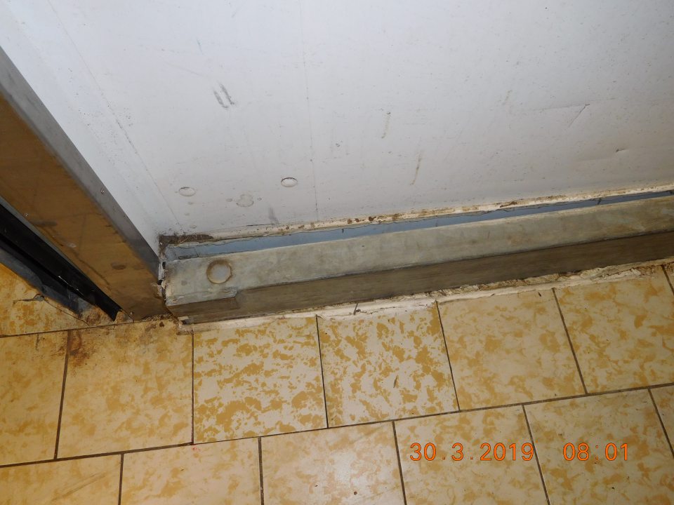 V  priestore skladu oproti vstupu do vonkajšieho prostredia mechanické poškodenie podlahovej lišty, porušenie až úplný rozpad tesniaceho tmelu okolo podlahovej lišty.