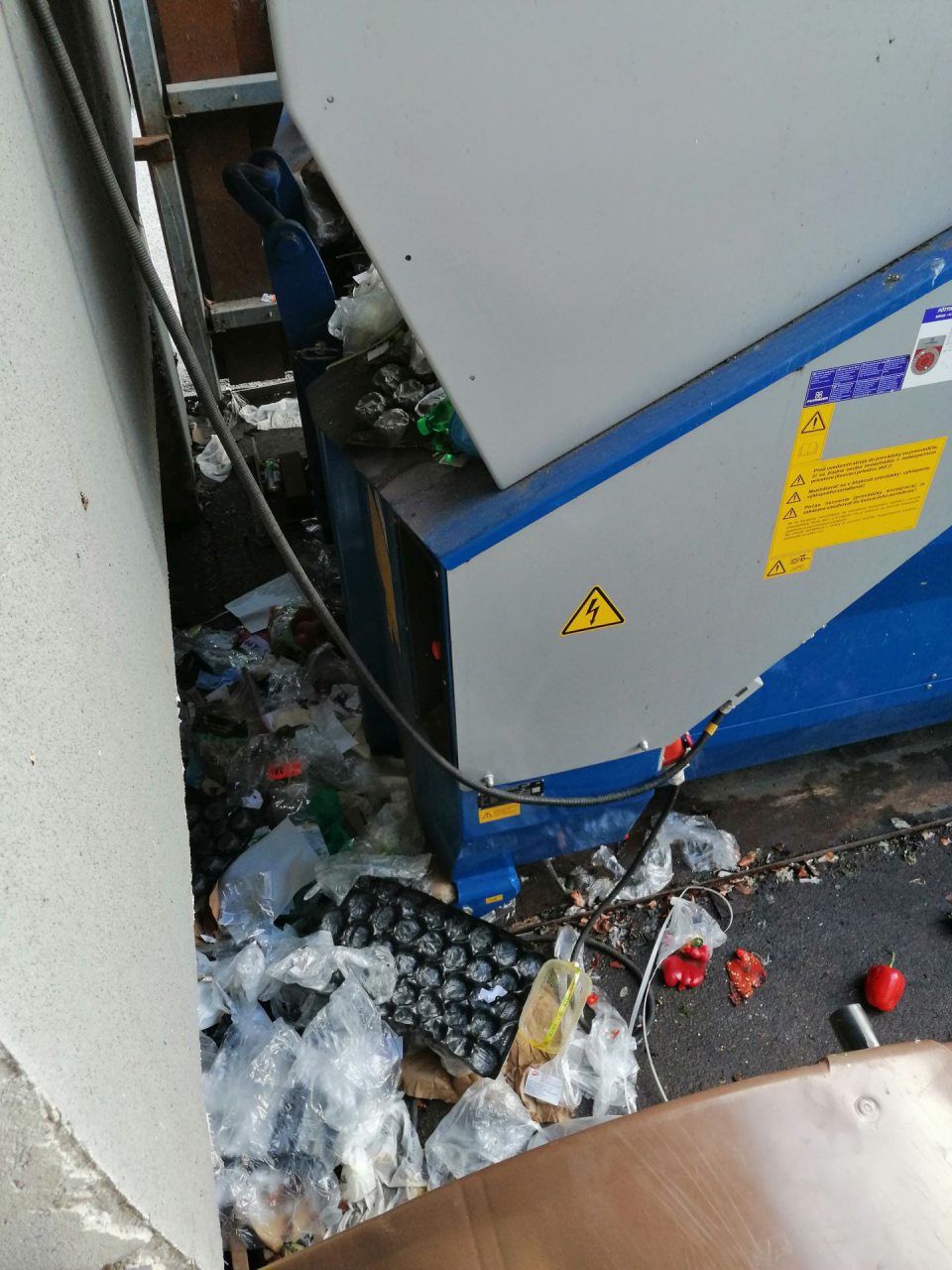 Nános nečistôt a odpadkov v okolí kontajnera.