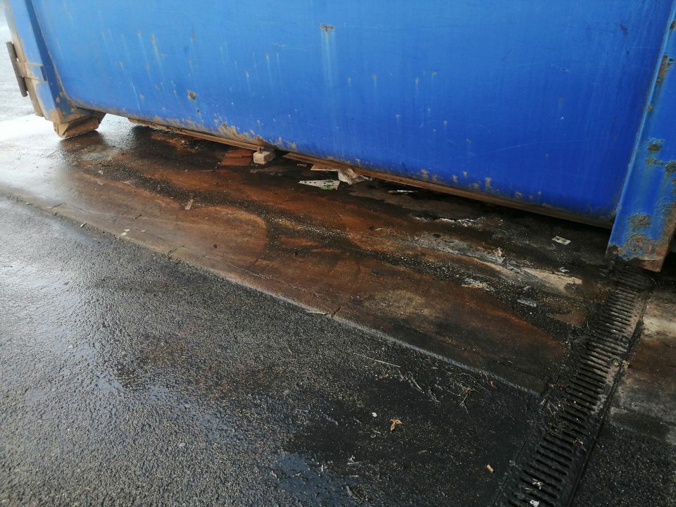 Zatečený povrch pod veľkokapacitným kontajnerom.