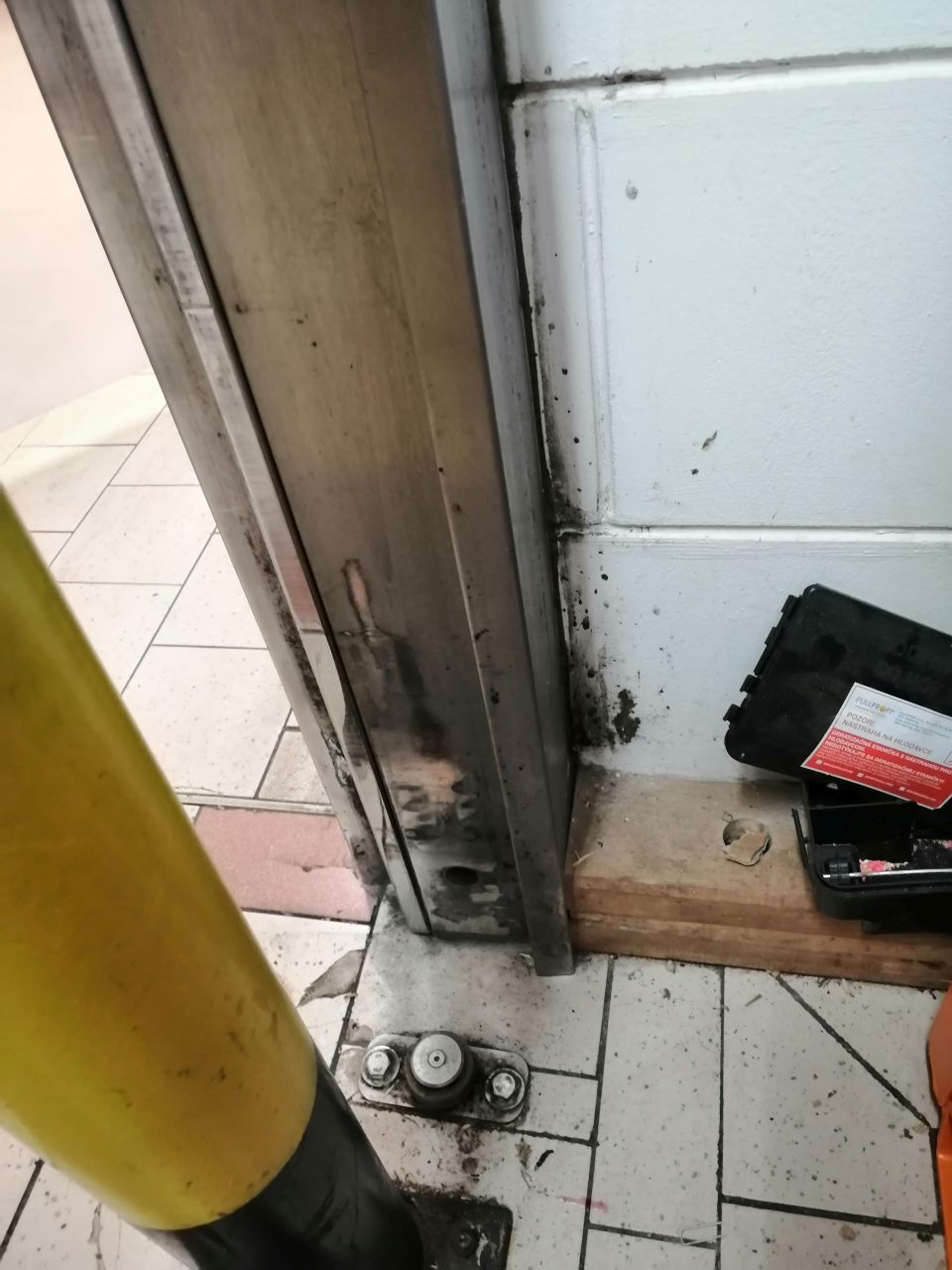 Znečistená stena pri vstupe do skladu čiernym povlakom.