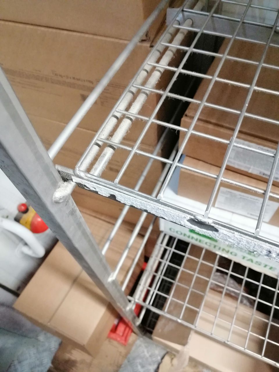 Zaprášené konštrukcie kovových regálov.