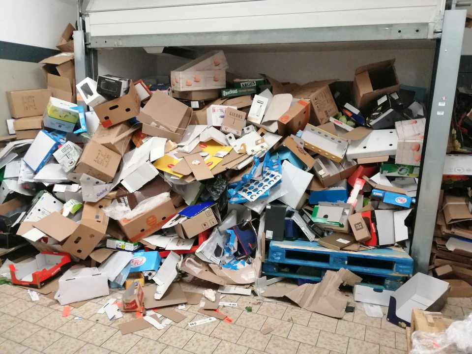 Umiestnené veľké množstvo kartónových obalov vo vnútornom priestore príjmu potravín.