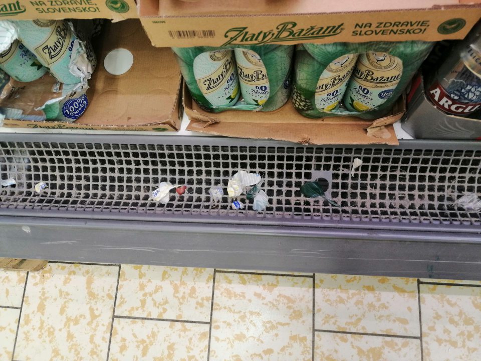 Výrazne zaprášená mriežka v chladiacej vitríne s nápojmi .