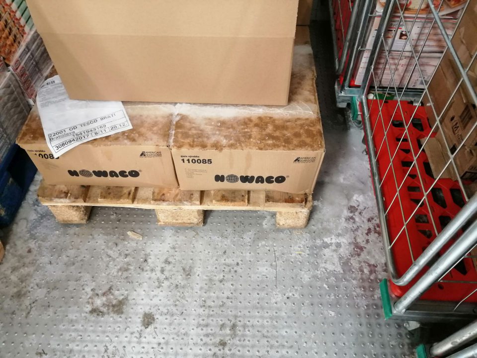 Vrstva ľadu na podlahe a kartónových krabiciach s výrobkami.