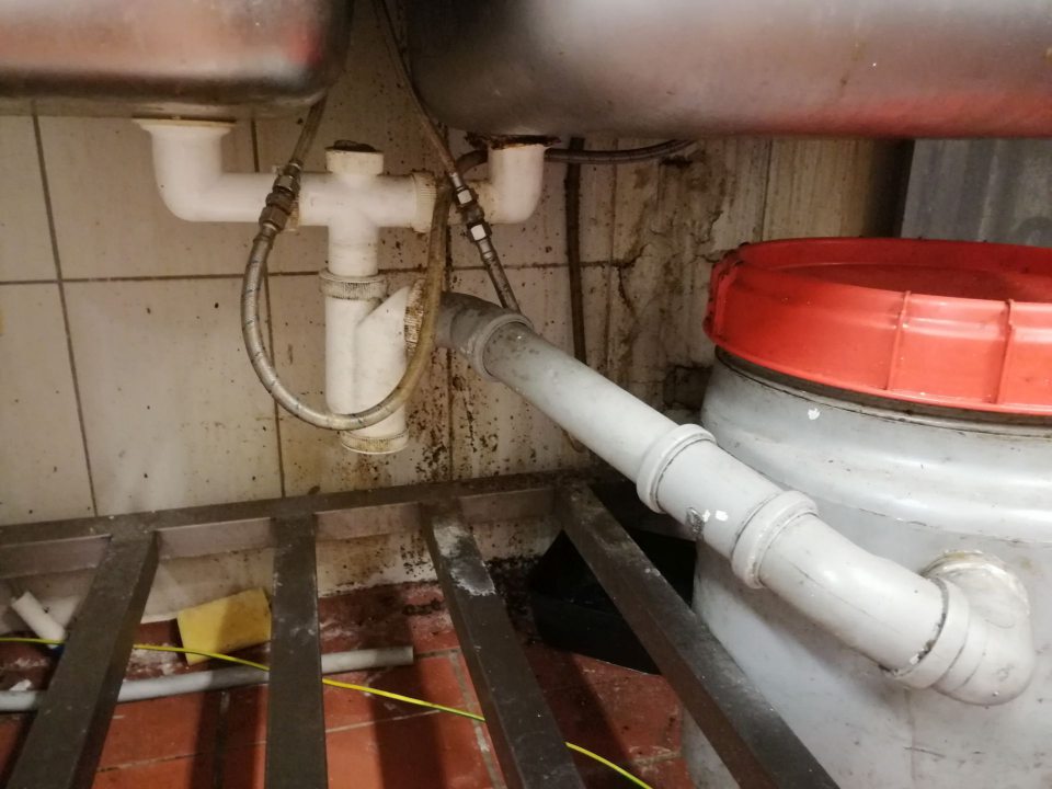 Výrazne znečistená stena pod stolom s drezmi v prípravovni lahôdok.