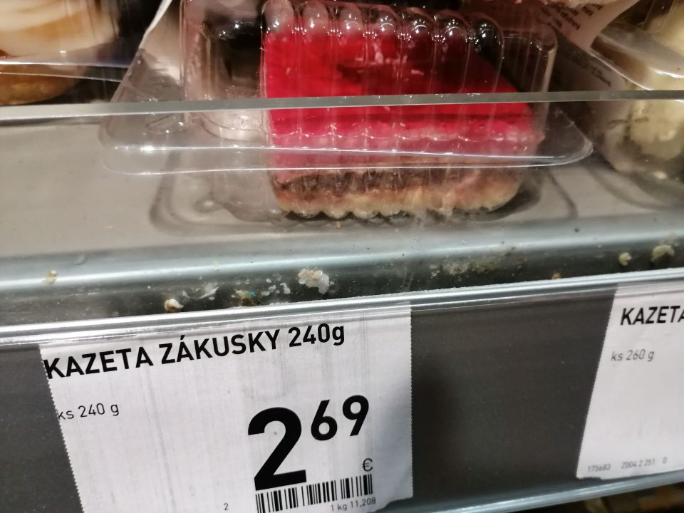 Znečistený priestor pod cenovkovými lištami v chladiacej vitríne.