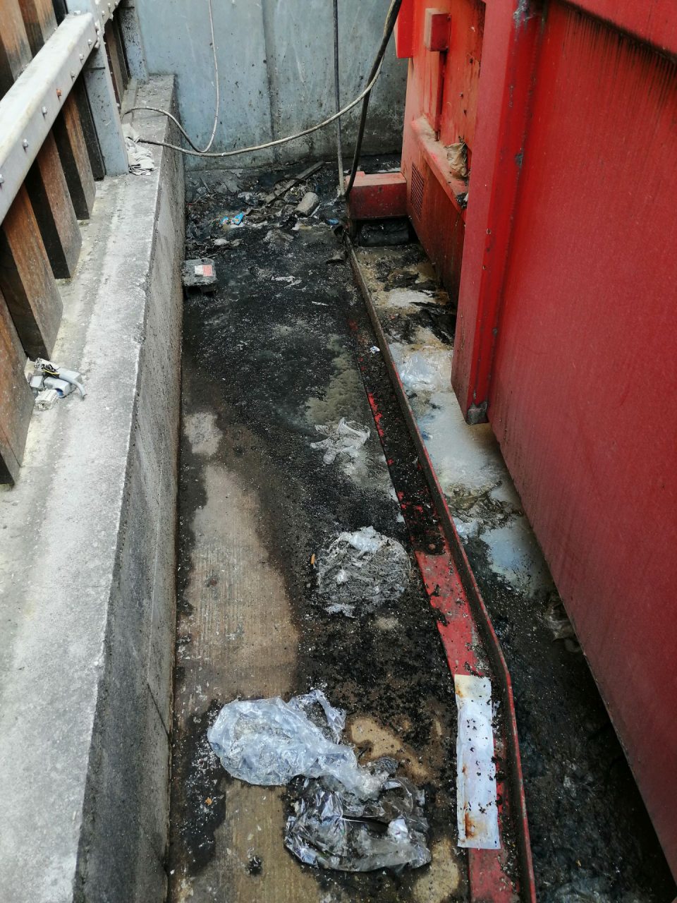 Znečistený priestor v okolí veľkokapacitného kontajnera.
