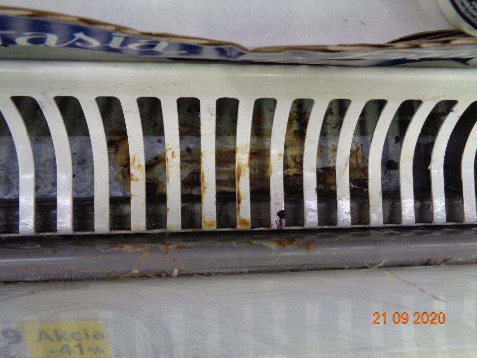 Chladiace vitríny na predajnej ploche s uloženými mliečnymi výrobkami vajciami mäsovými výrobkami v časti kovových mriežok znečistené zaprášené