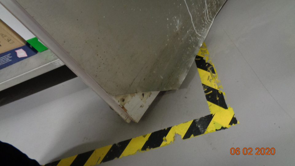 poškodená oplechovaná spodná časť dverí v sklade čistiacich potrieb. 