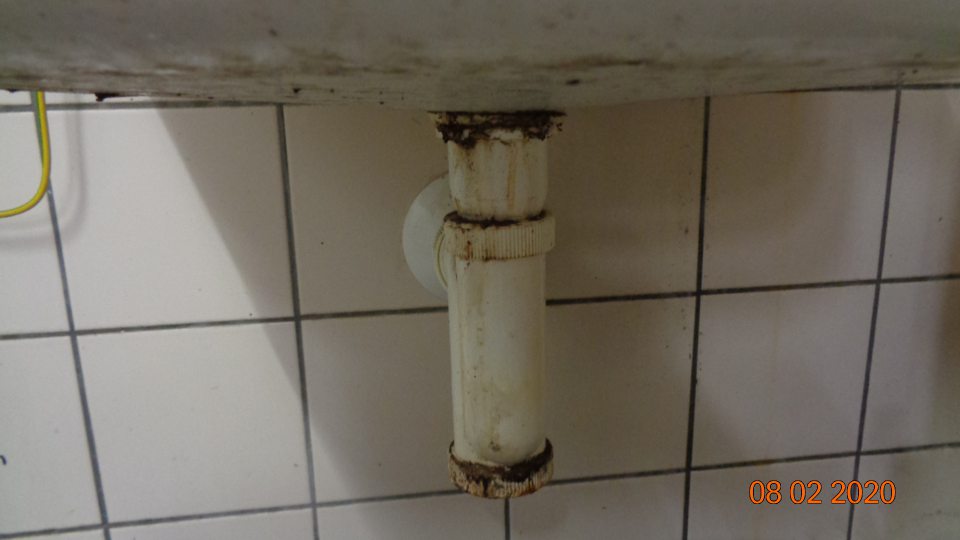 Umývadlo v priestore výlevky znečistené z vonkajšej aj vnútornej strany, sifón umývadla upchatý nečistotami.