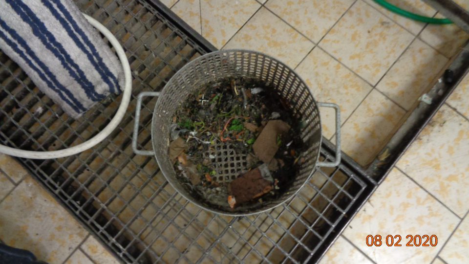 V priestore výlevky položený znečistený kôš z čistiaceho stroja.