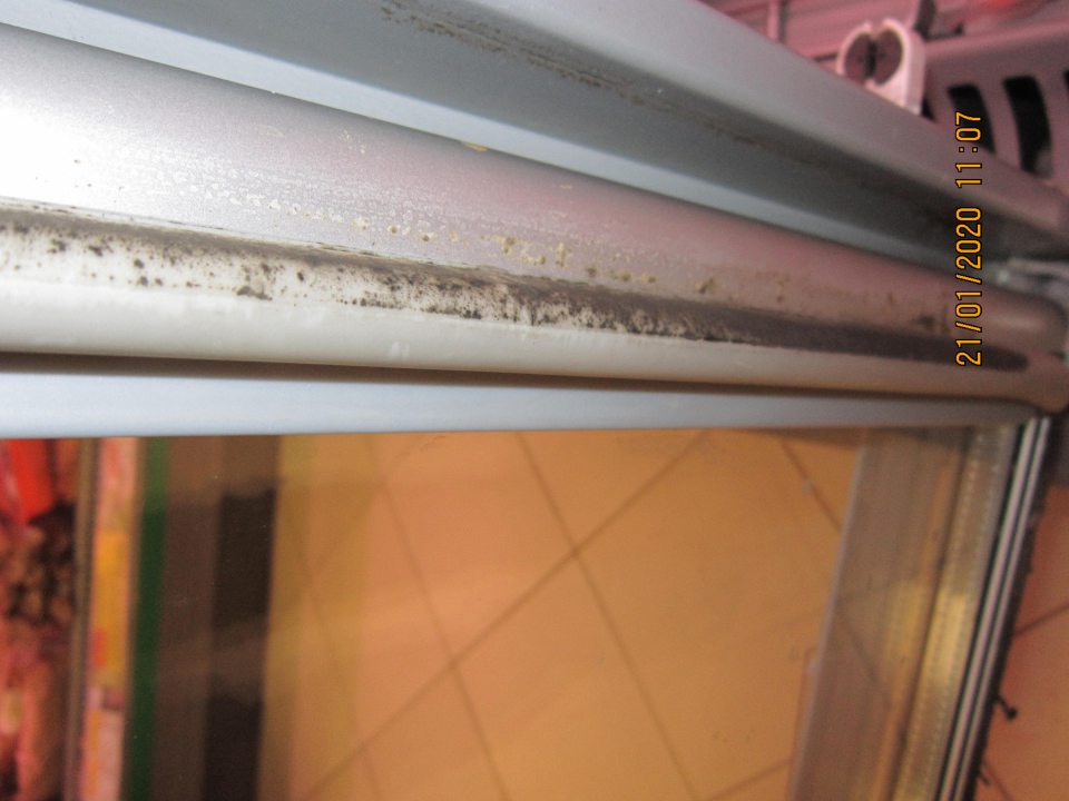Predajná plocha prevádzky - na dverách chladiarenských vitrín na mäsové výrobky zistené znečistené tesnenie od čiernej špiny (pravdepodobne od plesní) 