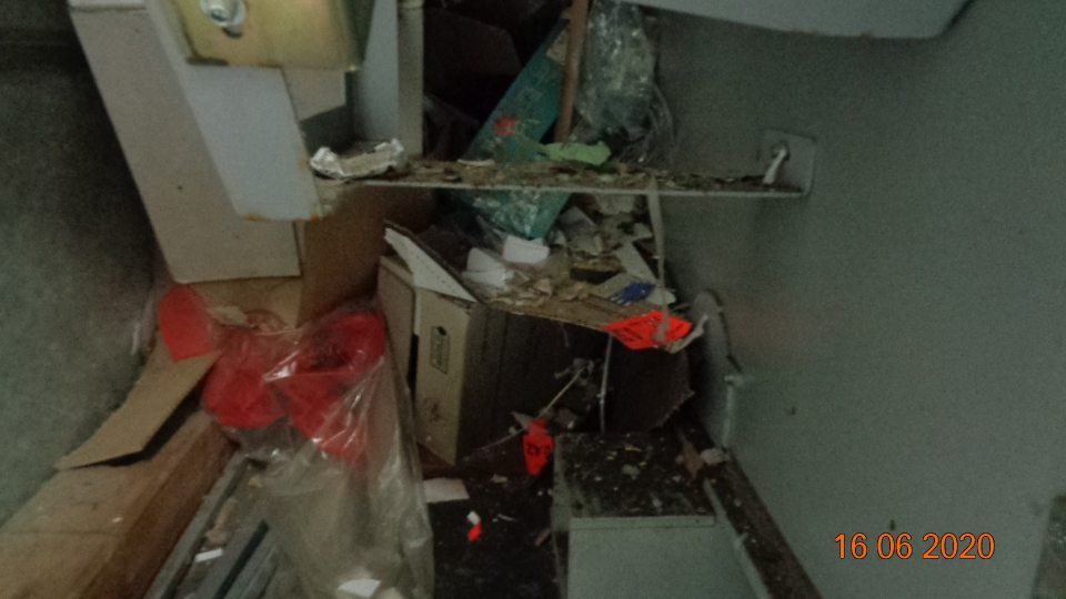 v sklade pri lise kartónov nahromadené zvyšky kartónov, plastové fólie, vrstva prachu, v mraziacom boxe TIKO pod paletami zbytky etikiet, omrvinky a chuchvalce prachu, v chladiacom boxe mäsných výrobkov a lahôdok podlaha pod kovovým regálom znečistená zaschnutou potečenou šťavou z lahôdok