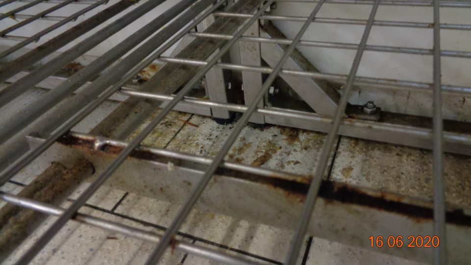 v chladiacom boxe mäsných výrobkov a lahôdok podlaha pod kovovým regálom znečistená zaschnutou potečenou šťavou z lahôdok