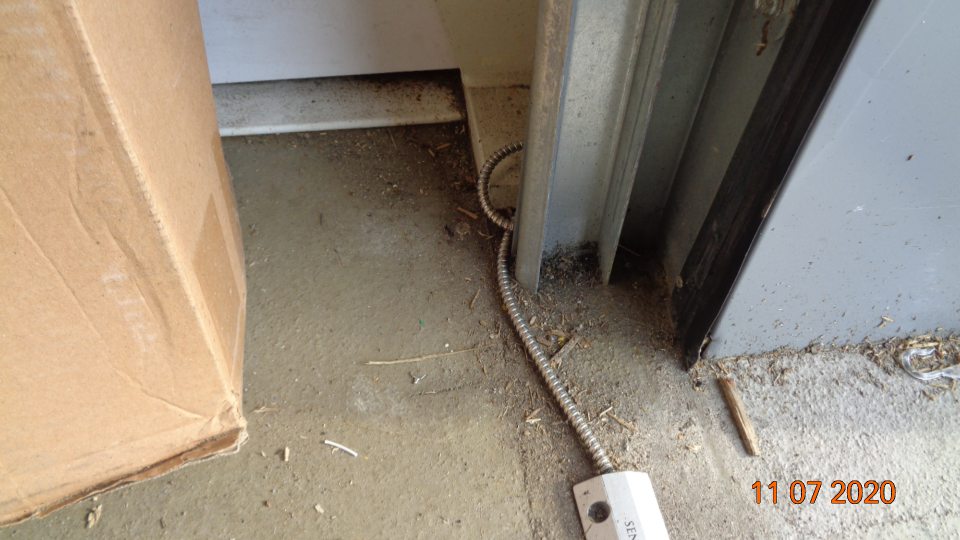 Podlaha v sklade znečistená čiernou špinou a vrstvou prachu, hlavne v rohoch.