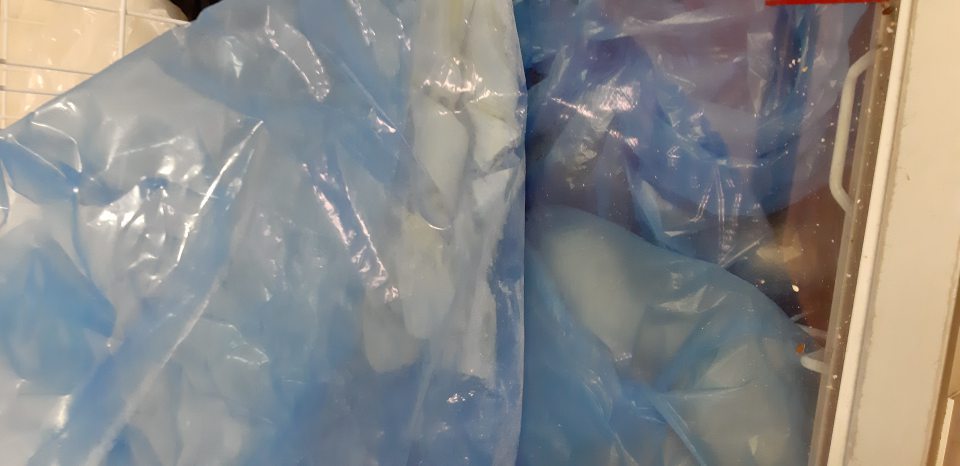 V sklade v mraziacej vitríne uložené hlbokomrazené pekárenské nepečené výrobky a mrazené donuty bez označenia na obale.