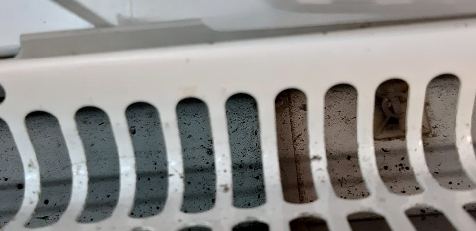 V chladiacej vitríne s uloženými mliečnymi výrobkami znečistený priestor pod mriežkou.