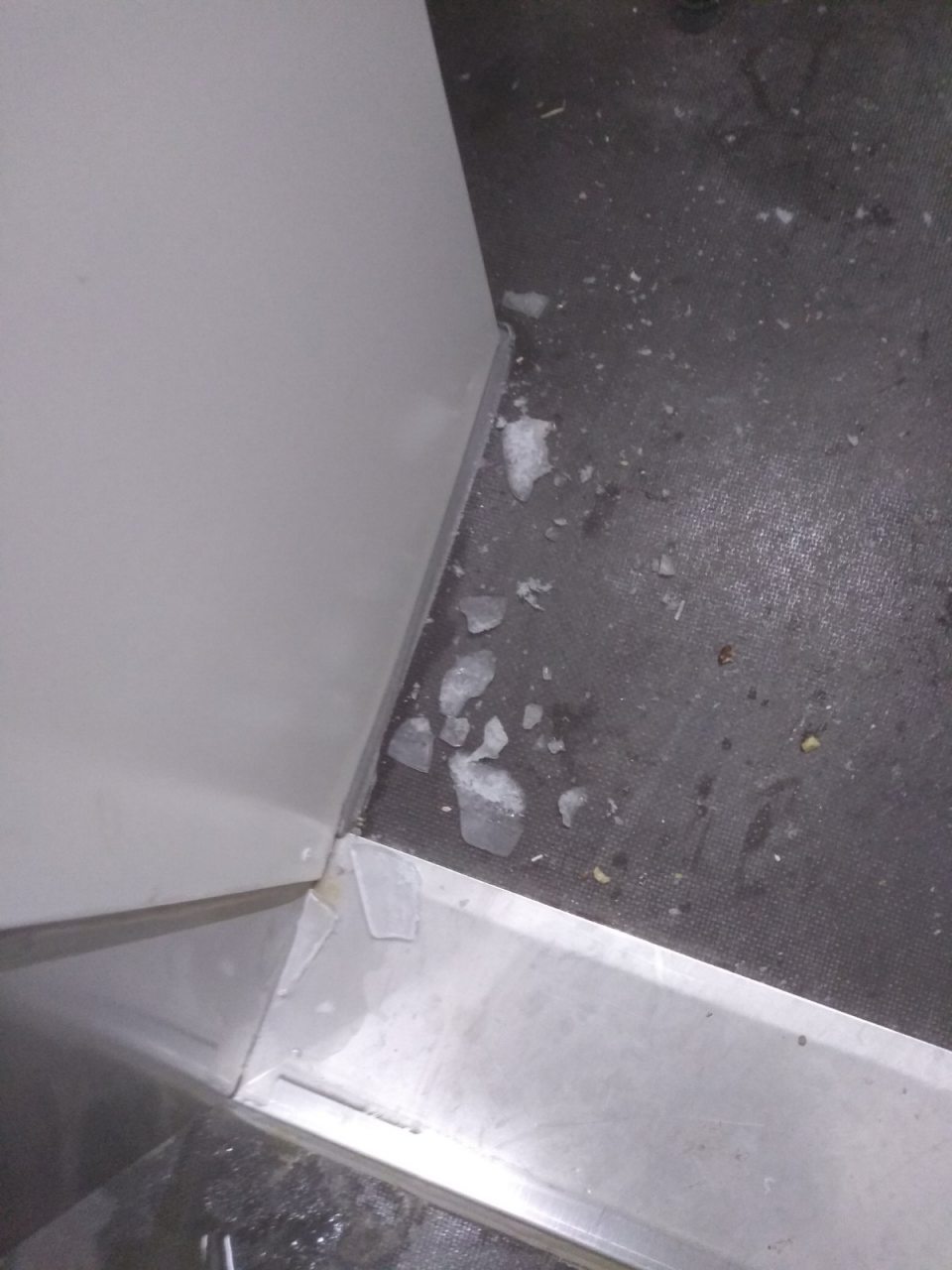 V mraziacom boxe v skladových priestoroch opadané úlomky zo zmrazeného kondenzátu na podlahe.