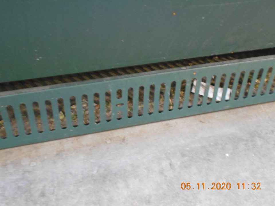 Znečistená podlaha pod regálom s vystavovanou čerstvou zeleninou na viacerých miestach.