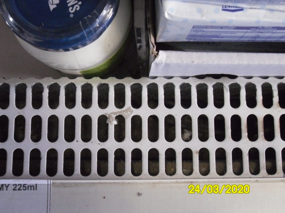 Znečistená chladiarenská vitrína pod mriežkou.