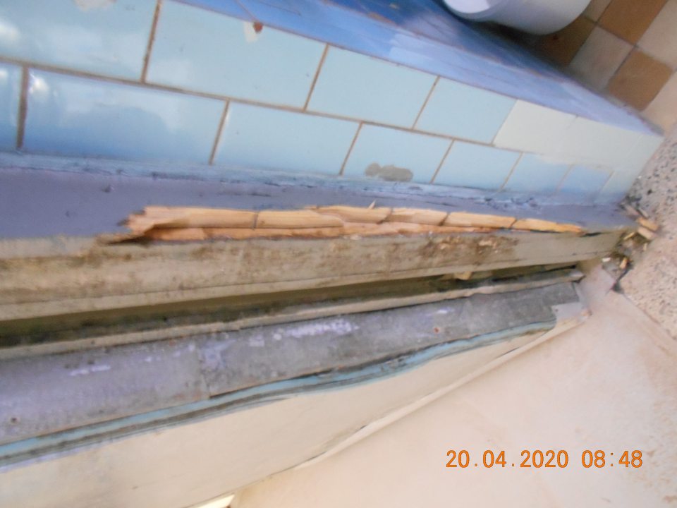 Poškodená, znečistená zárubňa chladiarenského boxu v sklade surovín.