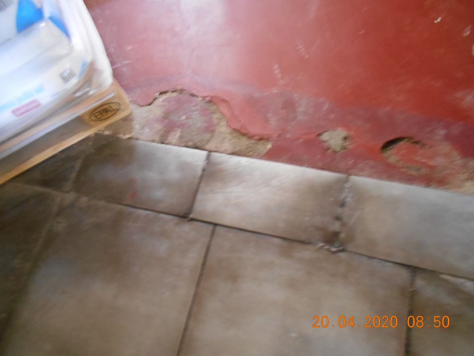 Výtlky v podlahe na viacerých miestach v chodbe oddelenia miešarne.