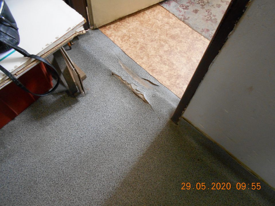 1.) Poškodená podlahová guma na viacerých miestach v skladovacích priestoroch predajne. 