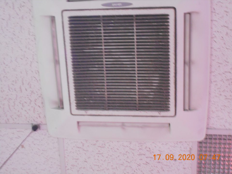 Znečistené stropné ventilačné zariadenie hrubou vrstvou prachu na predajnej ploche nad chladiarenským zariadením s uchovávaným čerstvým ovocím.