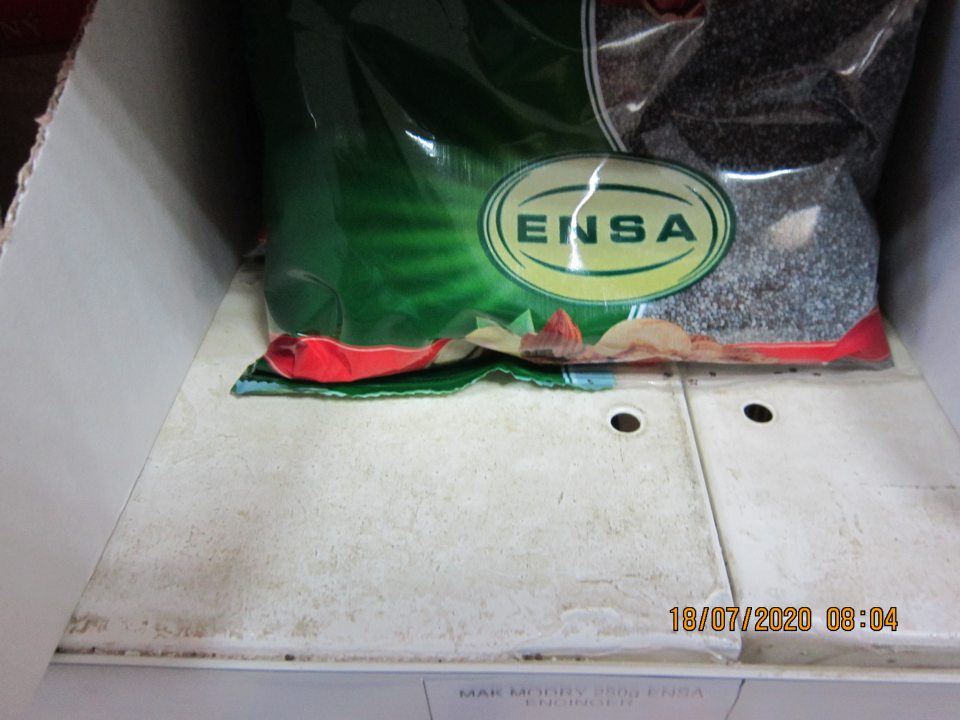 Regál na predajnej ploche, na ktorom je umiestnený balený mak, znečistený nánosmi zaschnutej špiny.