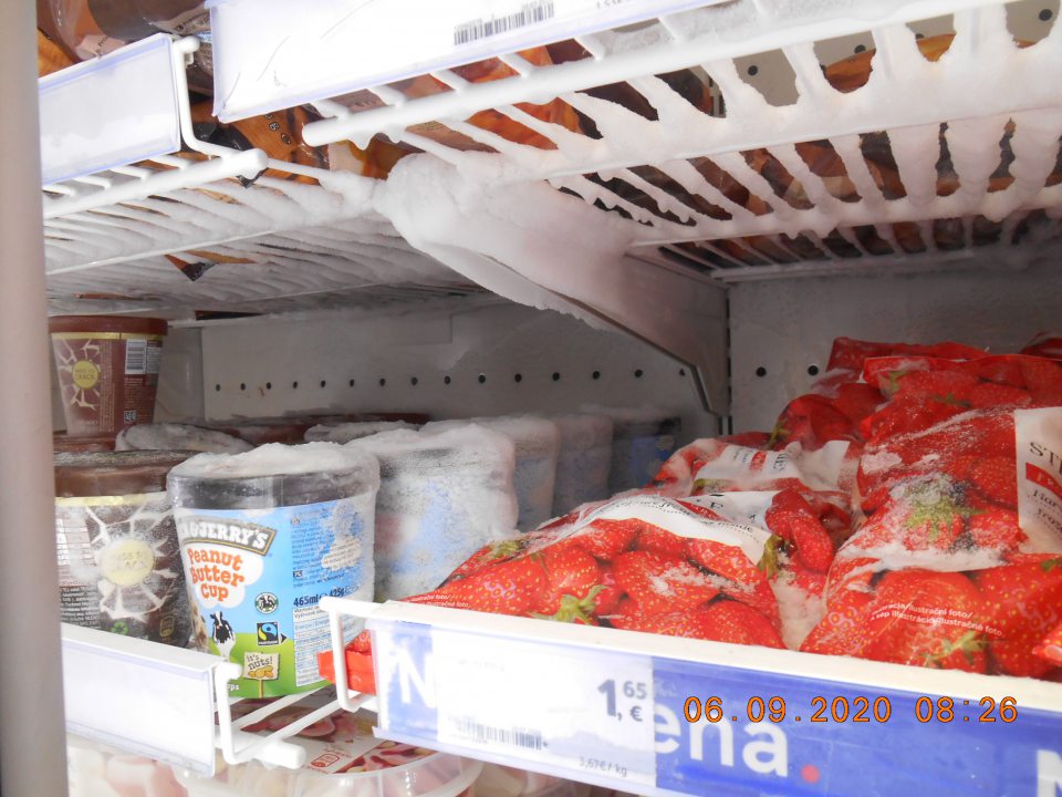 Námraza na mrazených krémoch a hlbokozmrazenom ovocí v mraziarenskej vitríne na predajnej ploche.