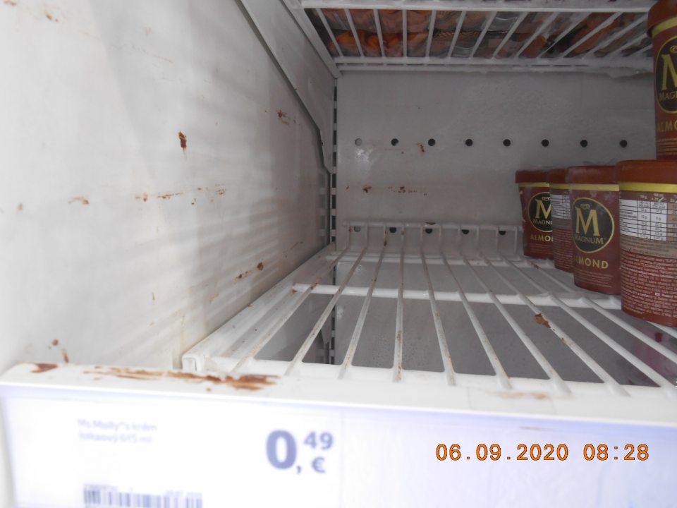 Znečistené steny mraziarenskej vitríny na predajnej ploche z roztopených mrazených krémov. 