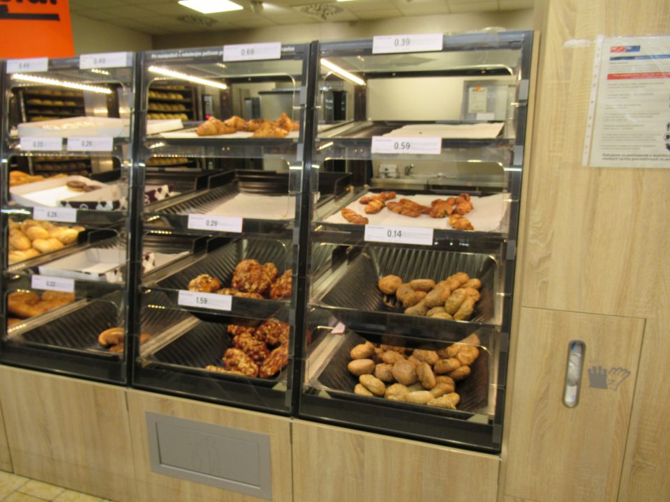 Nebalený pekársky tovar je predávaný v technických zariadeniach - regáloch bez predných ochranných krytov; výrobky sú chránené len z vrchnej strany horným regálom a z boku plastovými prepážkami.