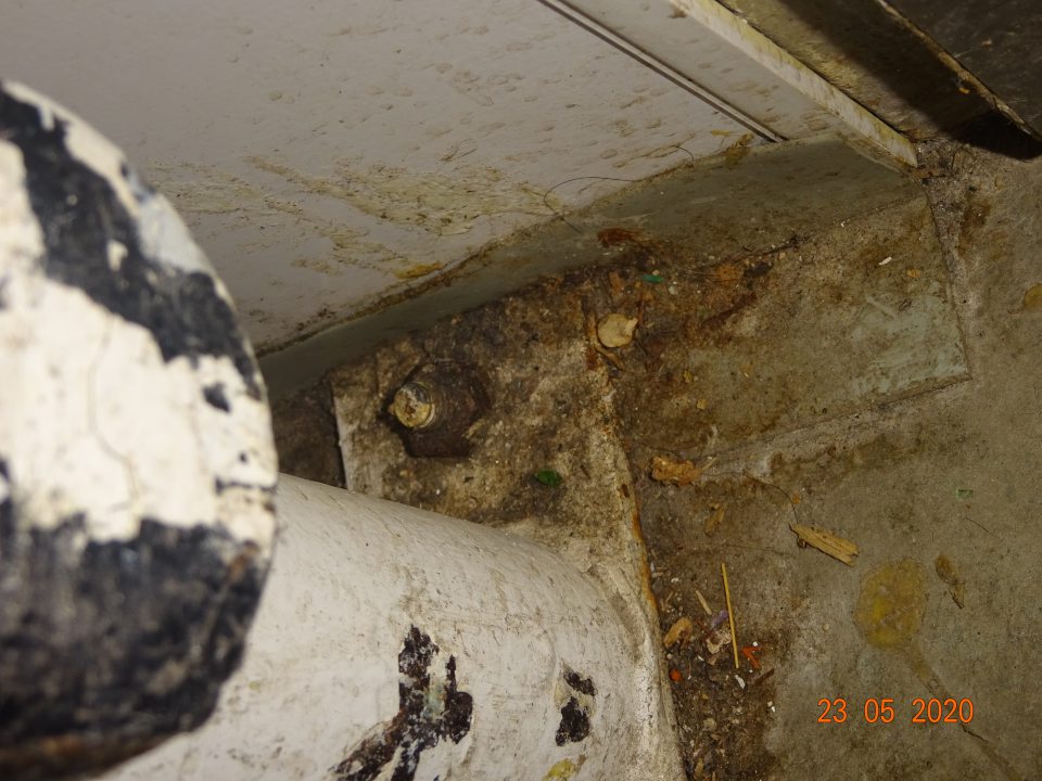 Znečistená podlaha v zázemí na viacerých miestach na ťažko dostupných miestach- za dorazovou lištou. 