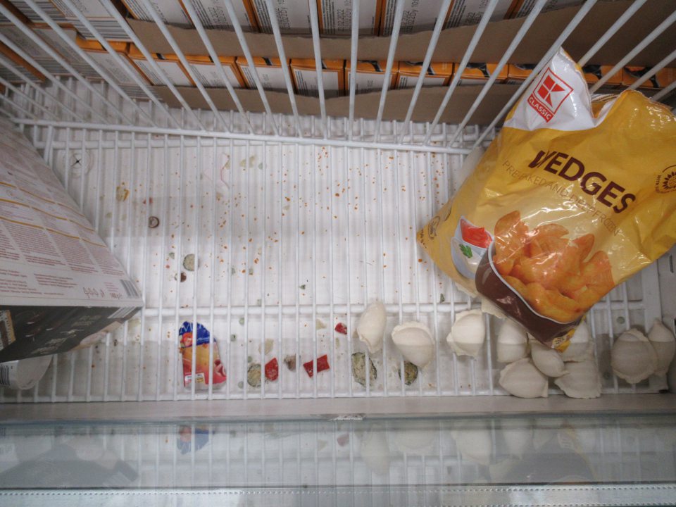 V chladiacom zariadení na predajnej ploche porozbaľované výrobky, zvyšky obalového materiálu, mechanické nečistoty pod mriežkami.