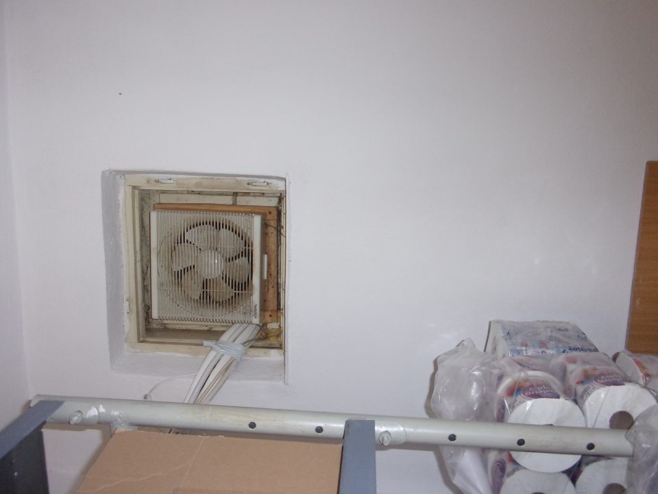 Nevyhovujúci hygienický stav ventilátora v zázemí umiestneného nad regálom s toaletným papierom - hrubá vrstva prachu, mechanické nečistoty, pavučiny.