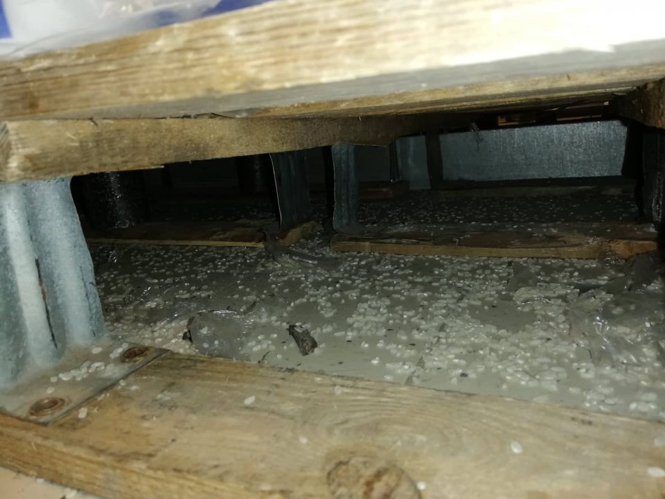 Zvyšky predávaných potravín pod regálmi na predajnej ploche.