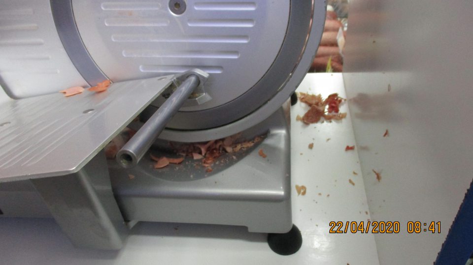  Nárezový stroj pri predaji mäsových výrobkov znečistený zvyškami potravín.