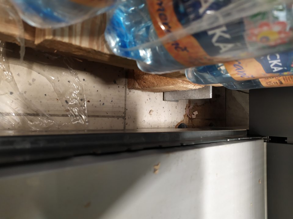 Znečistená podlaha medzi paletami na predajnej ploche.