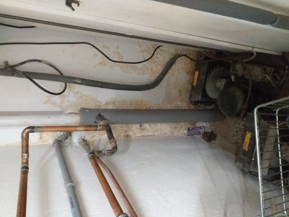 poškodená zavlhnutá omietka steny v sklade s chladiacimi a mraziacimi zariadeniami