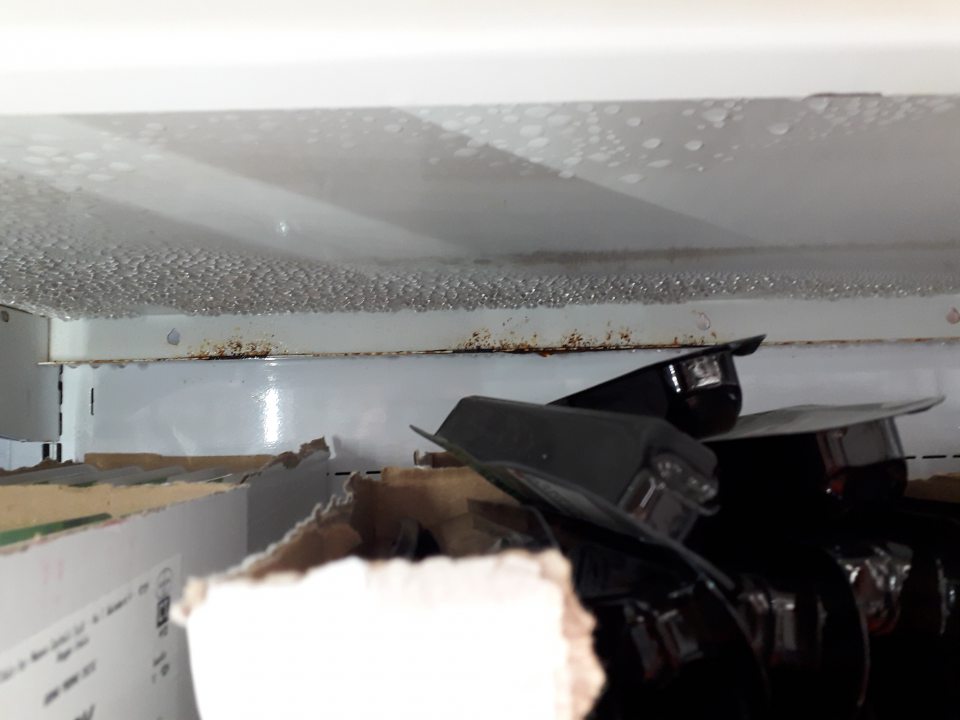 Na predajnej ploche v chladiacej vitríne s mliečnymi výrobkami - regál s prítomnosťou korózie.